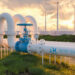 Hydrogen pipeline with windmills and solar panels in the background.